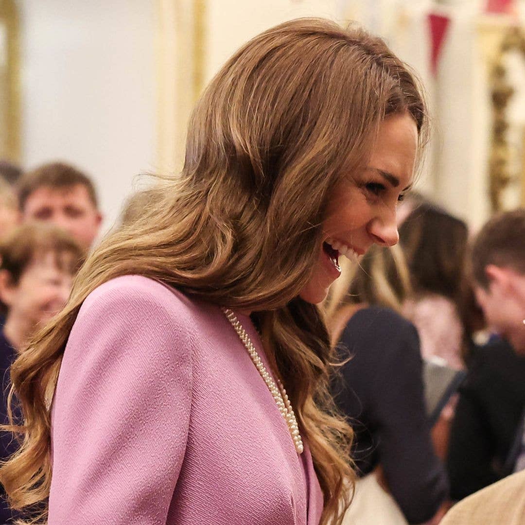 Princess Kate can't contain her giggles as she grabs Prince William mid-conversation