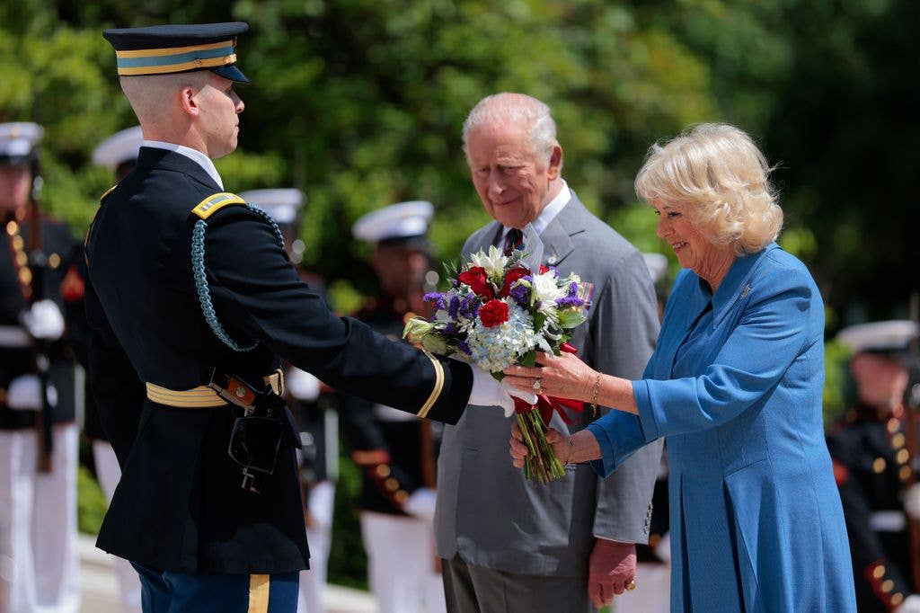 King Charles III and Queen Camilla present a bouquet of flowers at the Tomb of the Unknown Soldier during a ceremony at Arlington National Cemetery