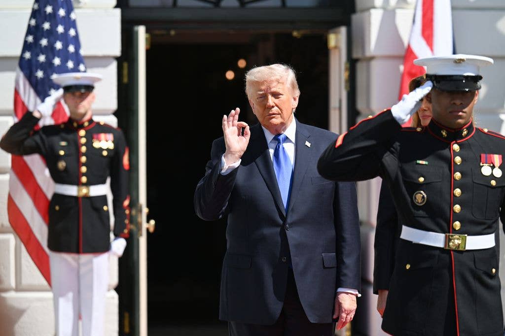 President Donald Trump poses during a farewell ceremony at the White House