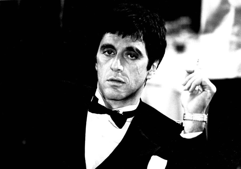 Black and white photo of Al Pacino as Tony Montana in a suit with a bowtie.